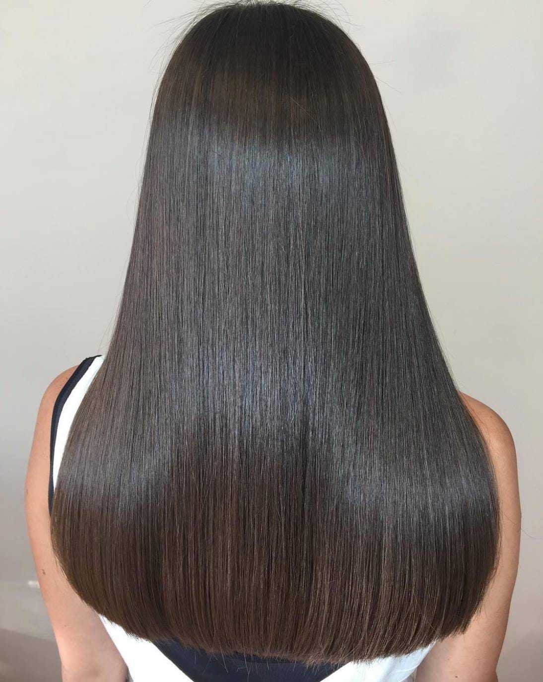 Shiny, healthy straight brown hair shown from the back.